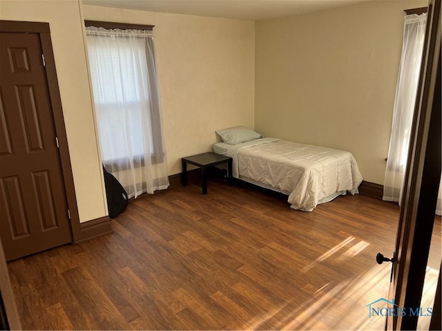 bedroom with dark wood-type flooring