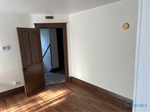 unfurnished room featuring dark wood-type flooring