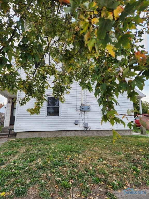 view of side of home with a yard