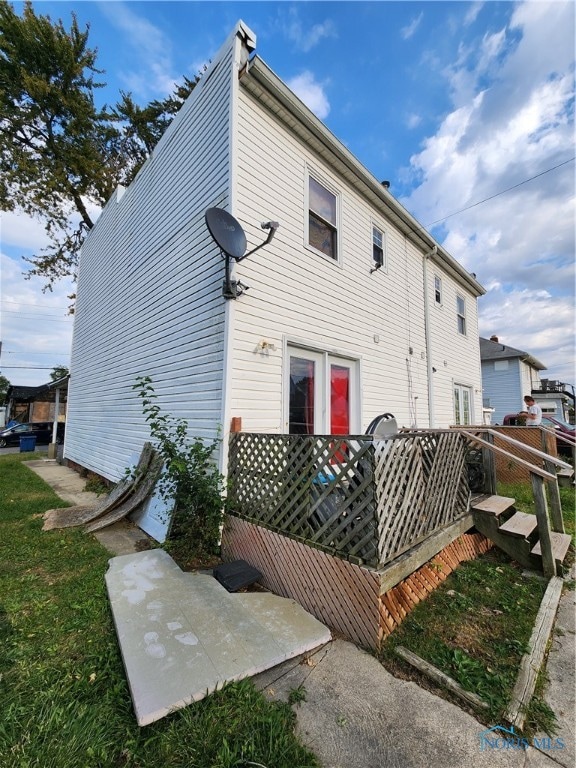 rear view of property featuring a wooden deck