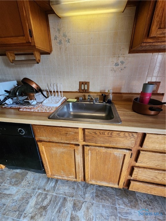 kitchen featuring dishwasher, backsplash, and sink