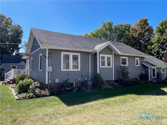 view of front of home featuring a front lawn and central AC