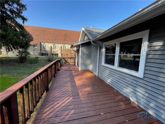 wooden deck featuring a lawn