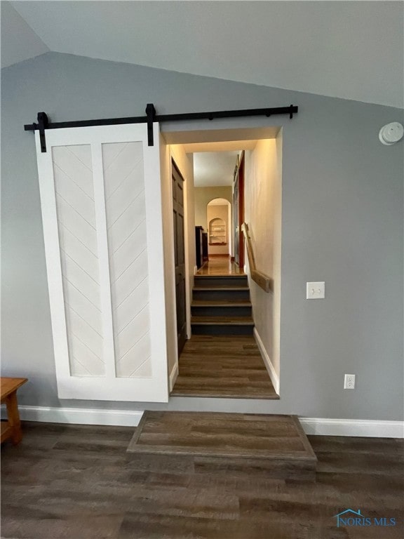 staircase featuring vaulted ceiling and wood-type flooring