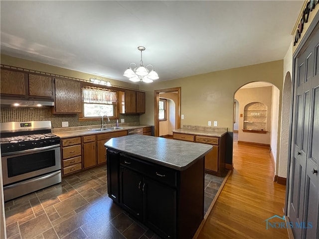 kitchen with a chandelier, a kitchen island, sink, stainless steel appliances, and dark hardwood / wood-style floors