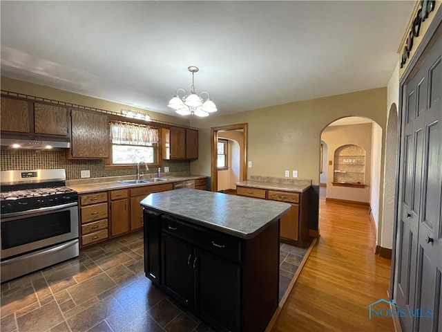 kitchen with extractor fan, a chandelier, a kitchen island, sink, and appliances with stainless steel finishes