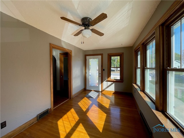 unfurnished sunroom with ceiling fan