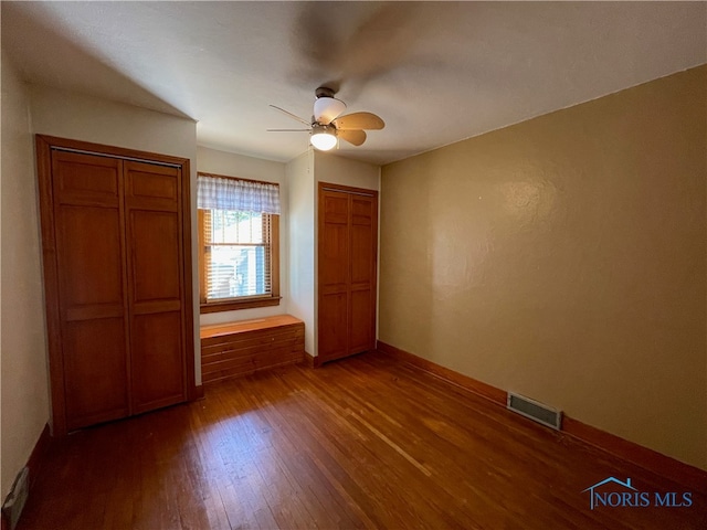 unfurnished bedroom featuring ceiling fan and dark hardwood / wood-style flooring