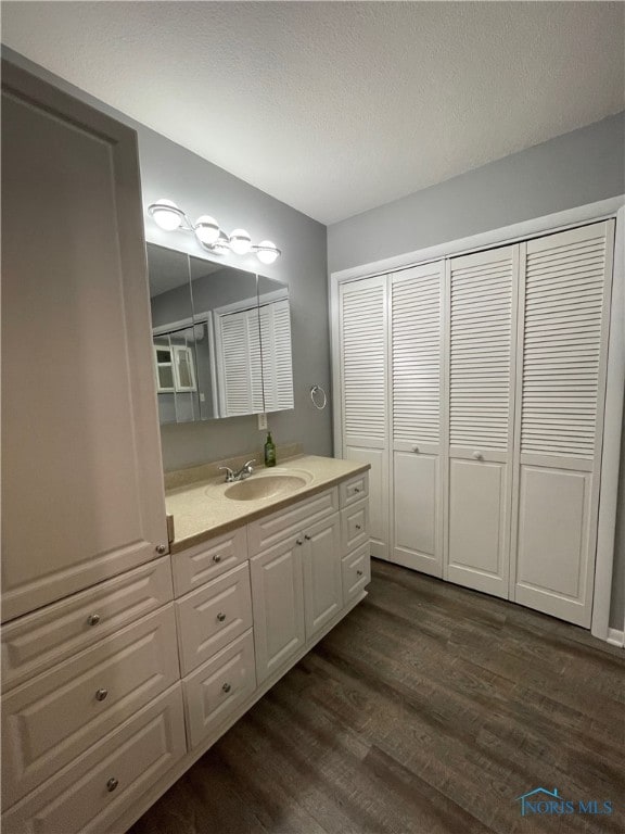 bathroom featuring hardwood / wood-style floors, vanity, and a textured ceiling