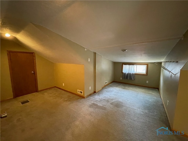 additional living space with light carpet and vaulted ceiling