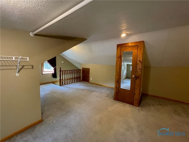 bonus room featuring light carpet, a textured ceiling, and vaulted ceiling