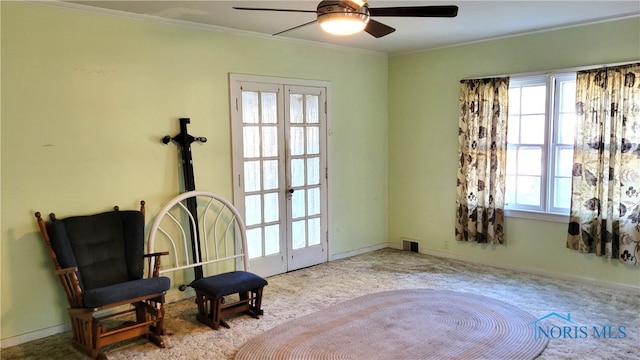 sitting room featuring ceiling fan, light carpet, a healthy amount of sunlight, and crown molding