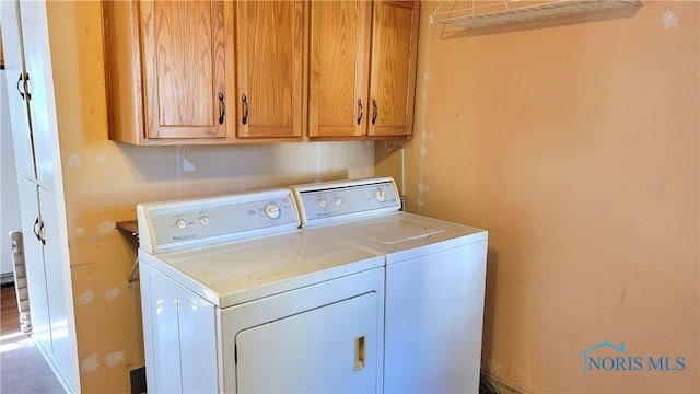 laundry area featuring washer and clothes dryer and cabinets