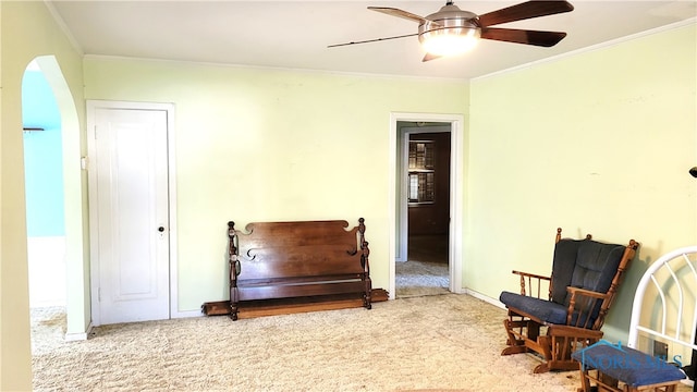 sitting room with ornamental molding, light carpet, and ceiling fan