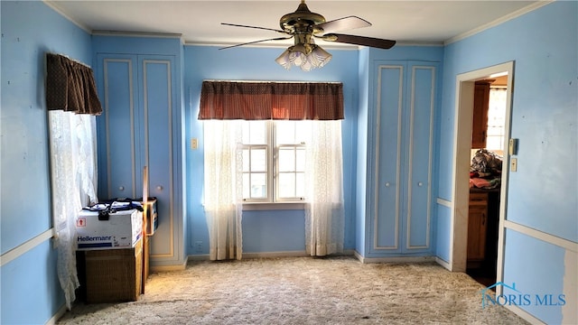 carpeted spare room featuring ornamental molding and ceiling fan