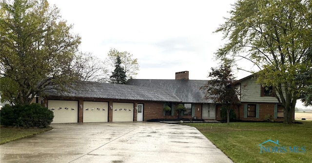 view of front of home with a garage and a front lawn