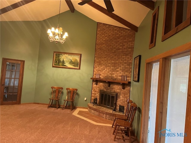 living area with high vaulted ceiling, beamed ceiling, a fireplace, a chandelier, and carpet flooring