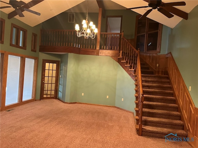 stairs with ceiling fan with notable chandelier, high vaulted ceiling, and carpet