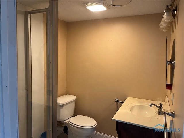 bathroom with vanity, toilet, and a textured ceiling