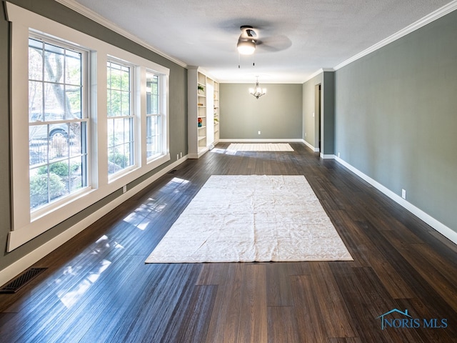 spare room featuring ceiling fan with notable chandelier, dark hardwood / wood-style floors, crown molding, and a textured ceiling