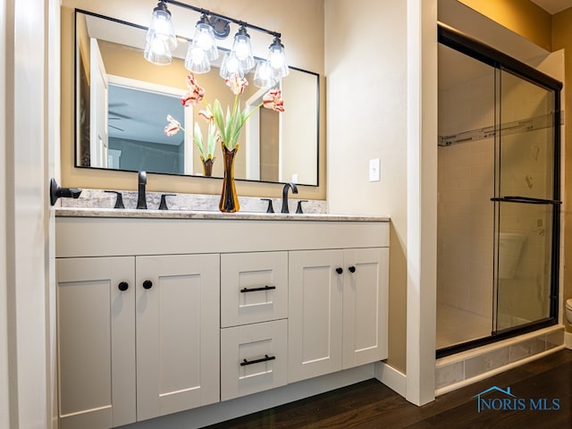 bathroom with hardwood / wood-style floors, an enclosed shower, and vanity