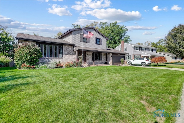 tri-level home featuring a front lawn and a garage