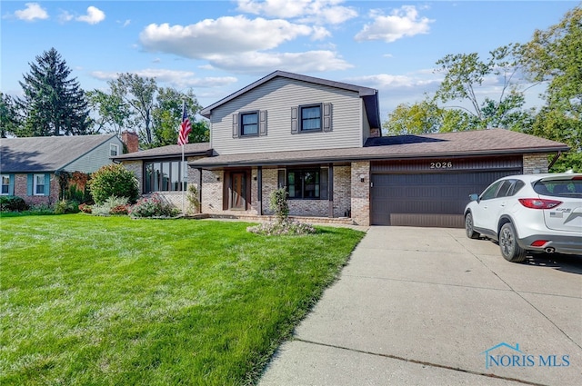 view of front of home with a front yard and a garage