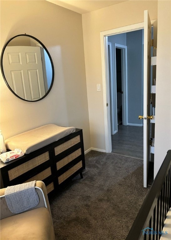 hallway with dark colored carpet