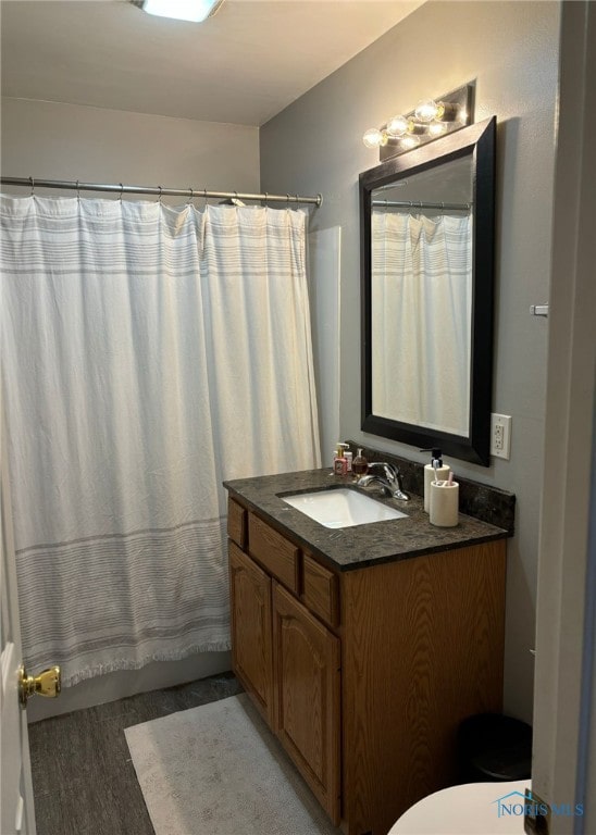 full bathroom featuring wood-type flooring, shower / bath combination with curtain, vanity, and toilet