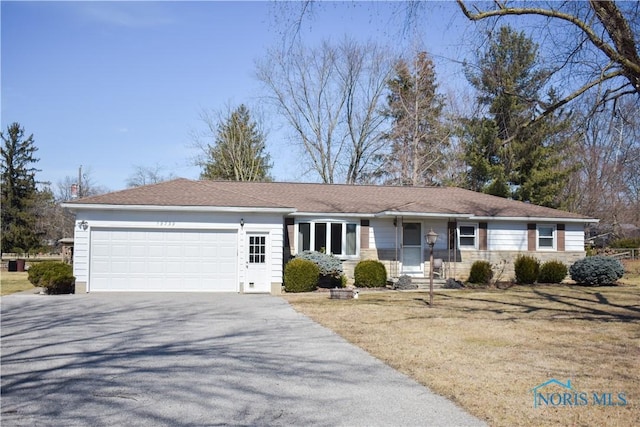 ranch-style home featuring aphalt driveway and an attached garage