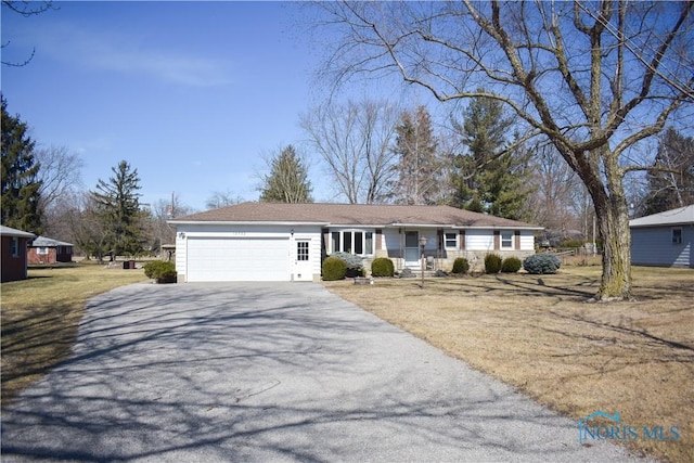 ranch-style home featuring driveway, a front lawn, and an attached garage