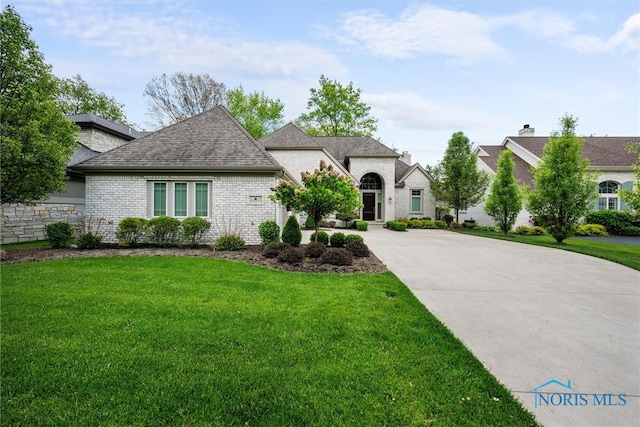 french country inspired facade featuring a front lawn