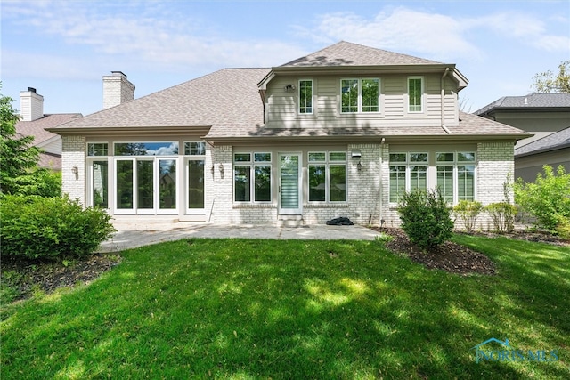 rear view of house featuring a yard and a patio area