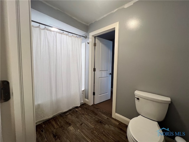 bathroom with toilet, hardwood / wood-style floors, and a shower with curtain