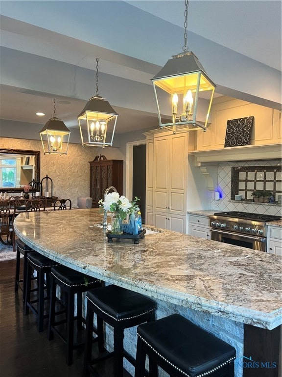 kitchen featuring hanging light fixtures, a breakfast bar, and stainless steel stove