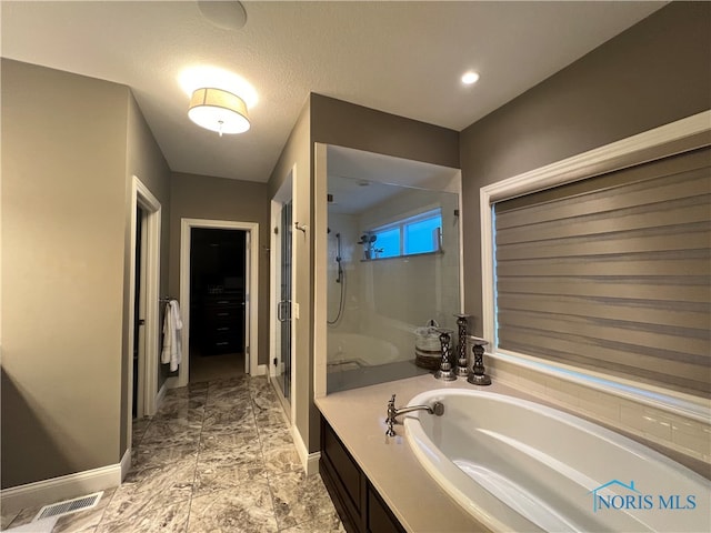 bathroom featuring vanity, shower with separate bathtub, and a textured ceiling