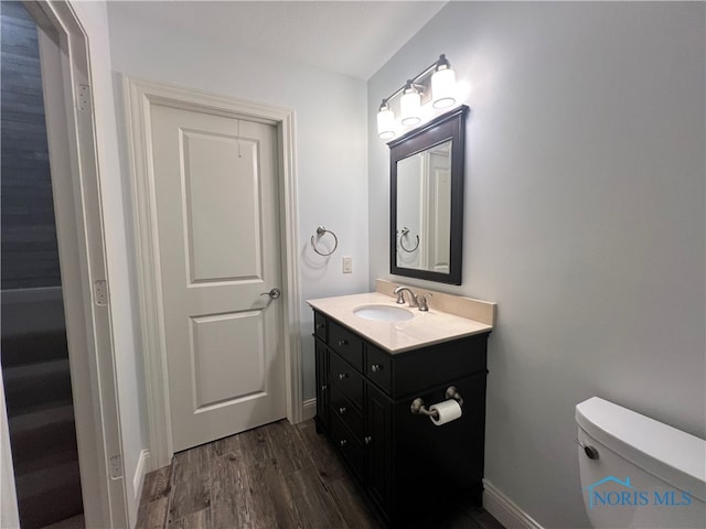 bathroom featuring vanity, hardwood / wood-style flooring, and toilet