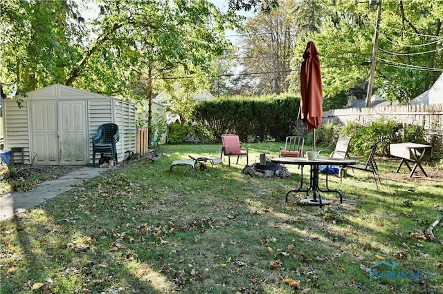 view of yard with an outdoor fire pit and a storage shed