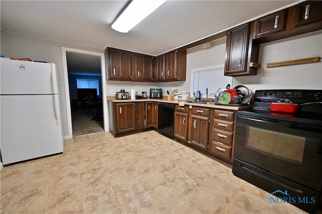 kitchen featuring dark brown cabinets, sink, and black appliances