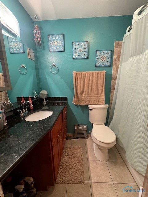 bathroom with tile patterned flooring, a shower with shower curtain, vanity, and toilet