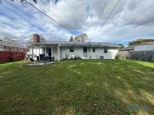 rear view of property featuring a yard and a patio