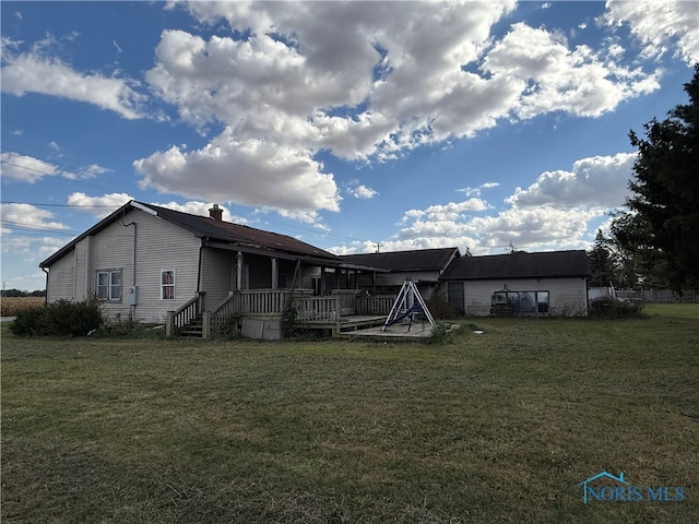 back of house featuring a wooden deck and a yard