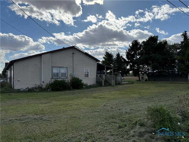 view of side of property with a lawn