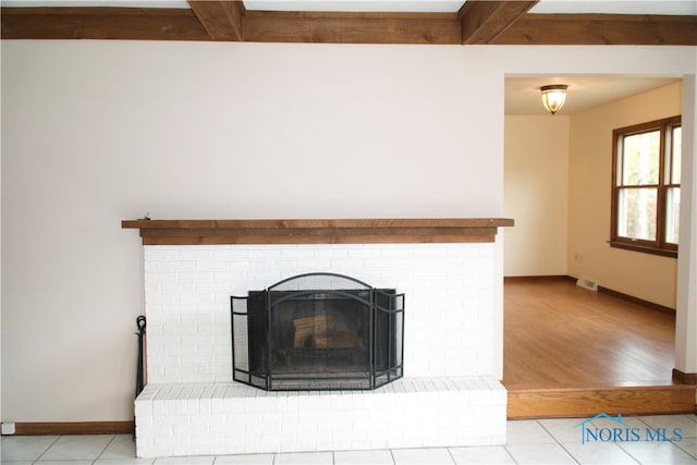 interior details with hardwood / wood-style flooring, beamed ceiling, and a brick fireplace