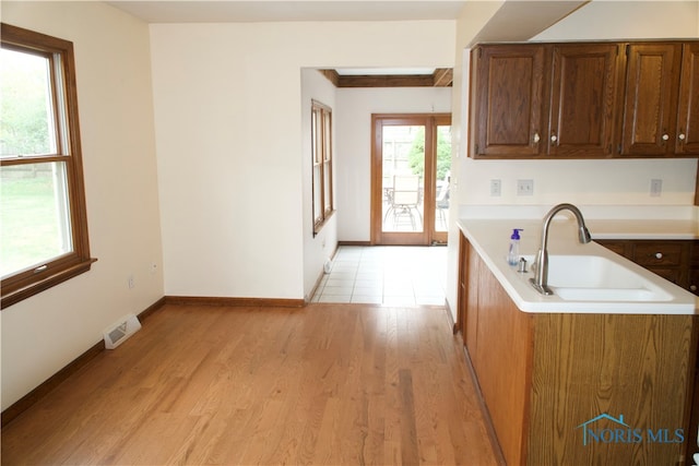 kitchen with sink, light wood-type flooring, and french doors