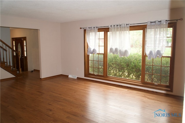 spare room featuring a textured ceiling and hardwood / wood-style flooring