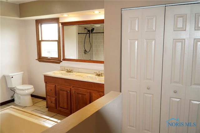 bathroom with vanity, toilet, tile patterned floors, and a washtub