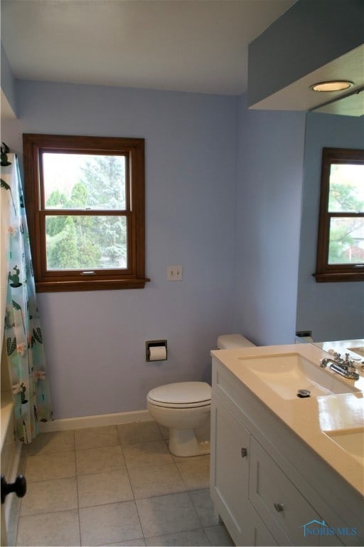 full bathroom with vanity, toilet, plenty of natural light, and tile patterned flooring