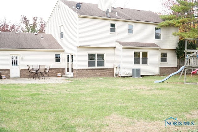 rear view of property with a playground, central AC unit, and a lawn