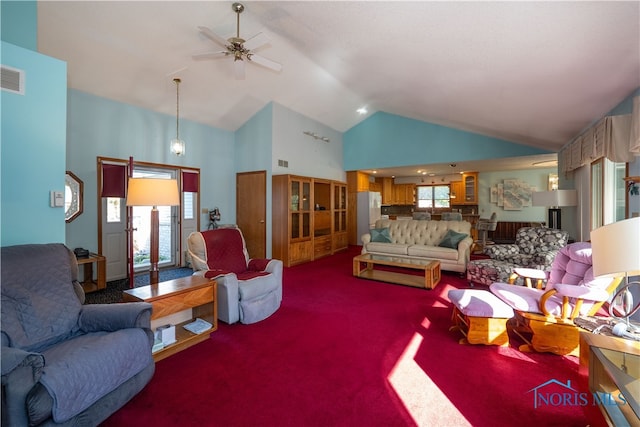 carpeted living room with ceiling fan and high vaulted ceiling